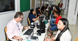 A imagem mostra uma sala de atendimento da Justiça Eleitoral, onde servidores realizam atendimen...