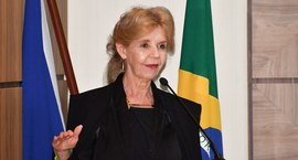 A imagem mostra a juíza Silvana Maria Parfieniuk, de cabelos loiros presos, falando ao microfone...