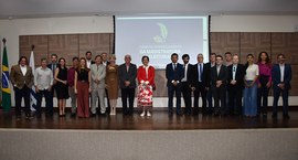 A imagem mostra um grupo de pessoas posando para foto oficial em um auditório. Elas estão dispos...