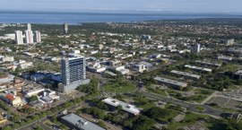 A imagem mostra uma vista aérea de Palmas, destacando seu urbanismo planejado, com ruas largas, ...