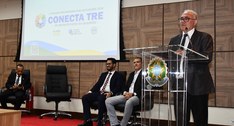 A imagem mostra um evento institucional realizado em auditório. À direita, o presidente do TRE-T...