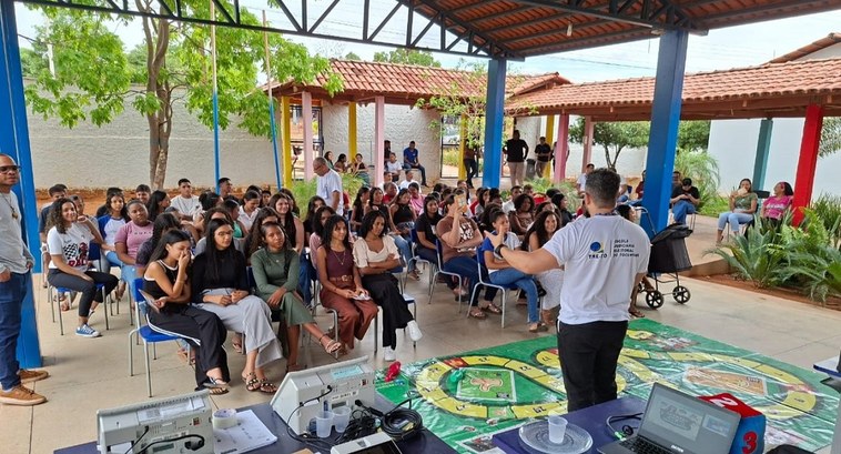 Agentes da Democracia: 26ª ZE leva educação política para estudantes em Mateiros A imagem mostra uma atividade educativa realizada em um espaço coberto, com várias pessoas senta...
