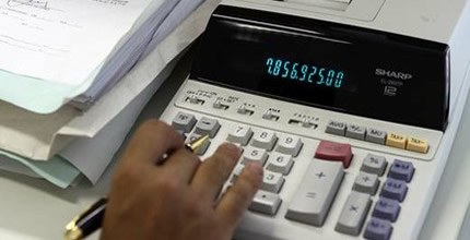 Calculadora Pessoa fazendo contas em calculadora de mesa