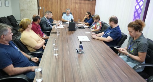 A imagem mostra uma reunião de trabalho a decorrer numa sala de conferências moderna. Cerca de n...