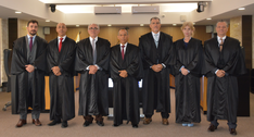 A imagem mostra os sete magistrados do TRE-TO posando para uma foto oficial no plenário. Todos e...