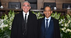A imagem mostra os desembargadores Adolfo Amaro Mendes e João Rodrigues Filho, sorridentes, em p...