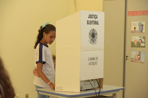 Eleições unificadas grêmios estudantis foto de estudante votando na cabina de votação