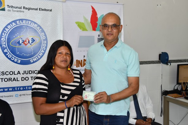 Indígena destaca importância do trabalho de inclusão sociopolítica promovido pelo TRE-TO e adesão de parceiros Juiz José Maria Lima entregando identidade a mulher indígena
