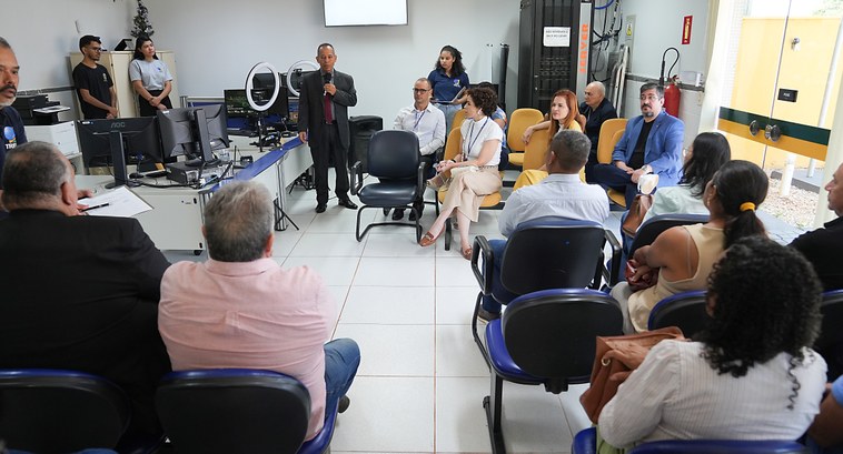 A imagem mostra um ambiente interno de reunião no cartório da 35ª Zona Eleitoral. Diversas pesso...