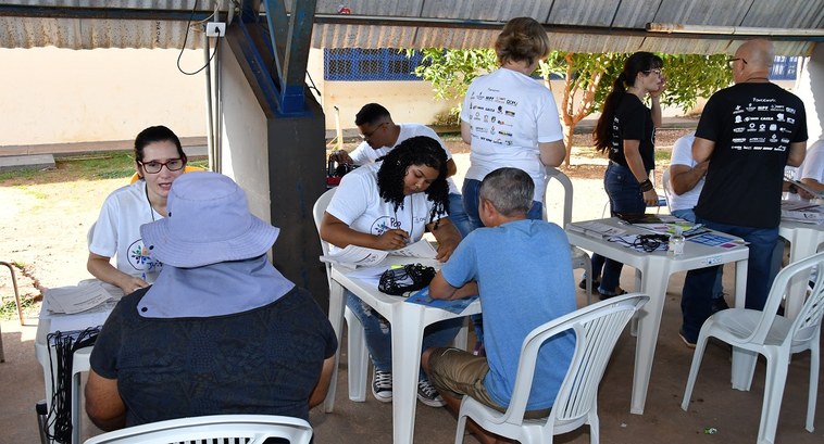 Justiça Eleitoral do Tocantins participa do 2º mutirão Pop Rua Jud no próximo dia 12 A imagem mostra uma ação comunitária realizada em espaço aberto, sob uma cobertura simples. Há v...