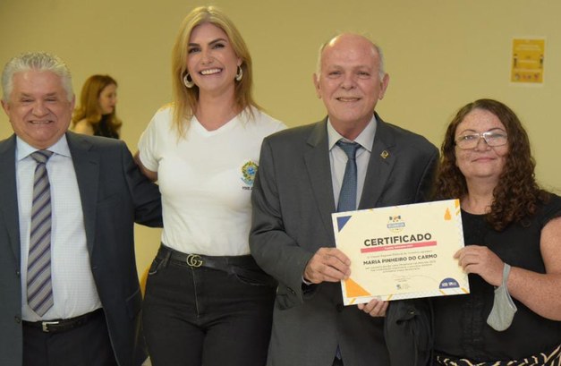Mesários são homenageados pela Justiça Eleitoral do Tocantins Imagem colorida de homenageada com autoridades do TRE-TO