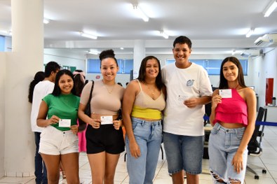 Mônica posa para a foto junto com os jovens segurando seus títulos de eleitor.