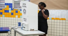 Mulher vota em urna eletrônica instalada em uma cabine de votação da Justiça Eleitoral, em uma s...