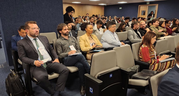 Servidora do TRE-TO participa do 4º Encontro Nacional de Comunicação do Poder Judiciário A imagem mostra uma sala de conferências ou auditório com várias fileiras de assentos ocupados p...
