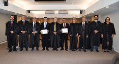 A imagem mostra um grupo de onze pessoas posando formalmente para uma foto no Pleno do TRE-TO. A...