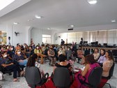 Imagem colorida do evento realizado, com participantes sentadas no formato roda de conversa