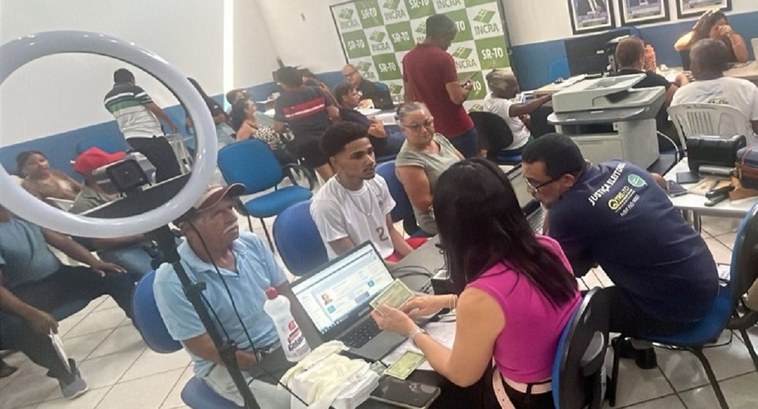 TRE-TO participa de mutirão de documentação voltado à população rural em Santa Fé do Araguaia A imagem mostra um ambiente de atendimento ao público bastante movimentado. Diversas pessoas est...