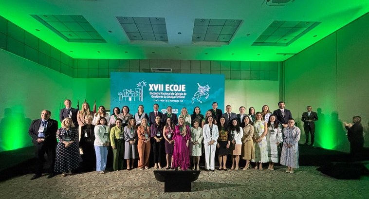 TRE-TO participa de XVII Encontro Nacional do Colégio de Ouvidores da Justiça Eleitoral A imagem mostra um grande grupo de pessoas posando para foto em um auditório, posicionadas à fre...