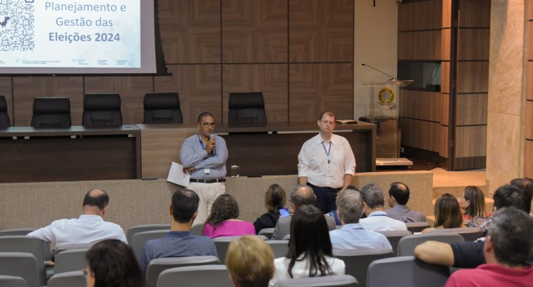 imagem colorida de pessoas sentadas em auditório assistindo apresentação do planejamento das ele...