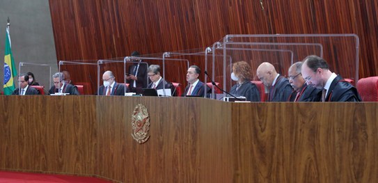 TSE aprova quatro resoluções com regras para as Eleições 2022 Foto de nove pessoas sentadas à uma mesa de autoridades.