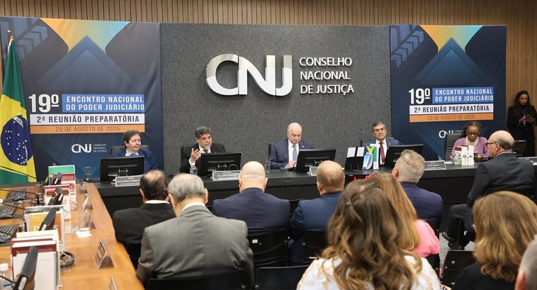 A imagem mostra uma reunião institucional do CNJ. No centro, uma mesa em formato de “U” acomoda ...